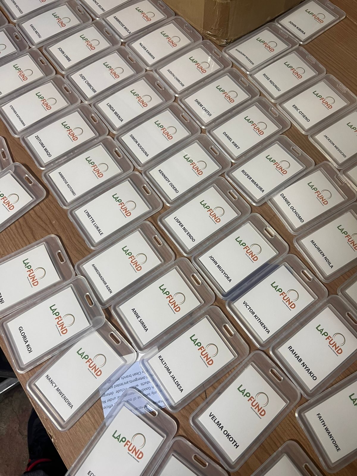 Bulk batch of LAPFUND branded ID card holders laid out for production